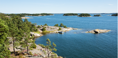 Skärgårdsbild med öar med små träd och vatten.
