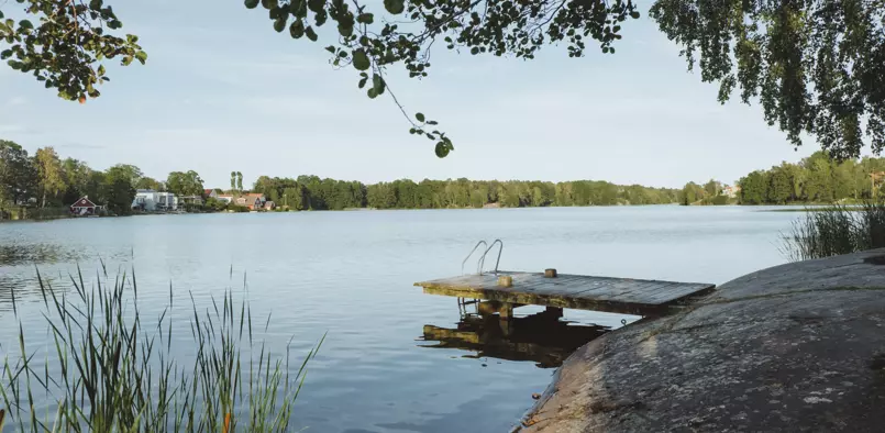 Vy över Långsjön med en brygga med badstege.