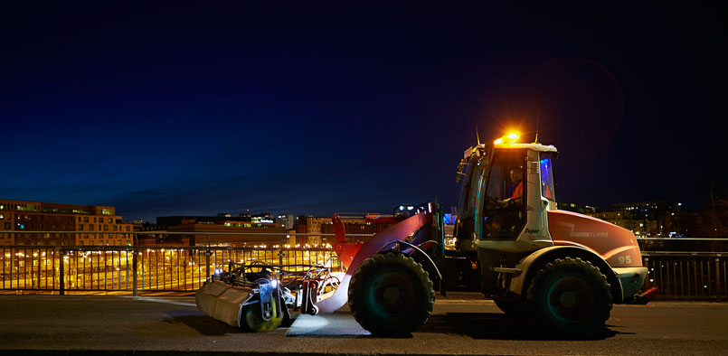 Traktor vid gata i kvällsljus 
