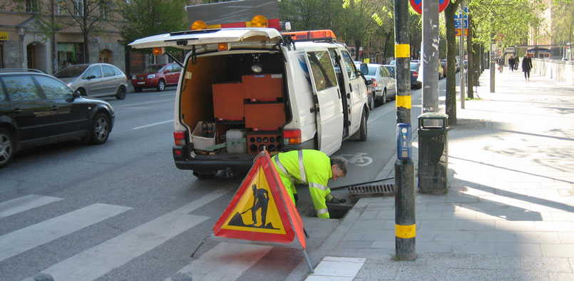 Arbete vid gatubrunnar i stadsmiljön